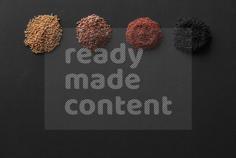 Black seeds, mustard seeds, garden cress and flax on a Black background
