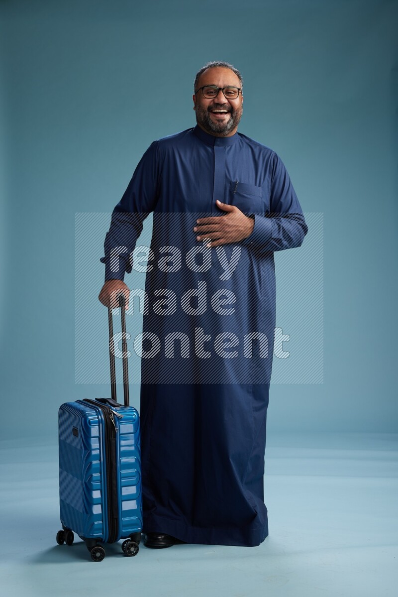 Saudi Man without shimag Standing pulling travel bag on blue background