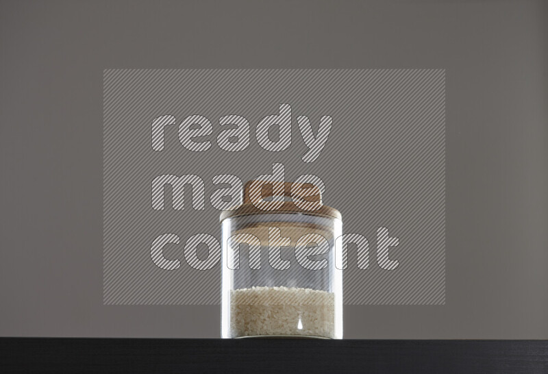 White rice in a glass jar on black background