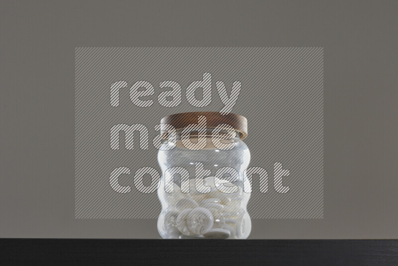 Buttons in a glass jar on black background