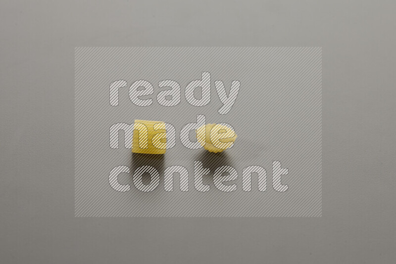 Big rings pasta with other types of pasta on grey background