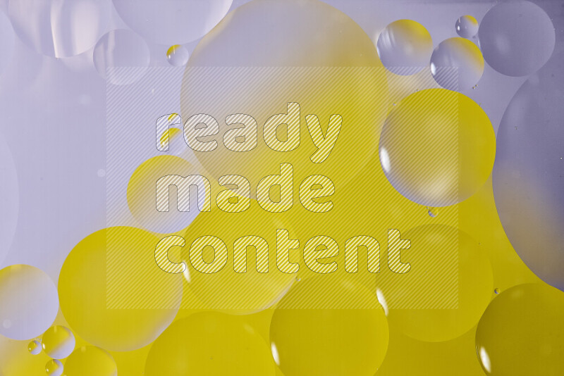 Close-ups of abstract oil bubbles on water surface in shades of white and yellow