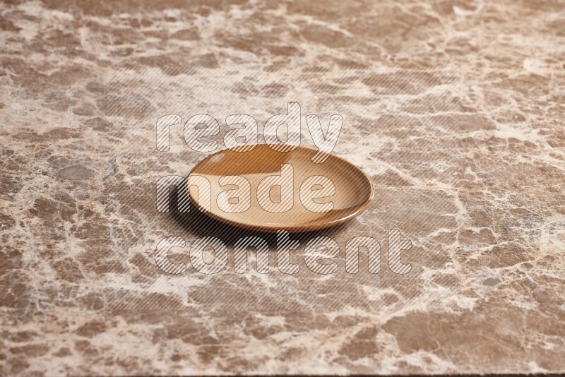 A multicolored pottery plate on beige marble background