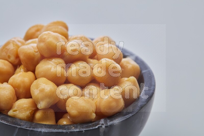 Close up of a boiled chickpeas in a container on white background