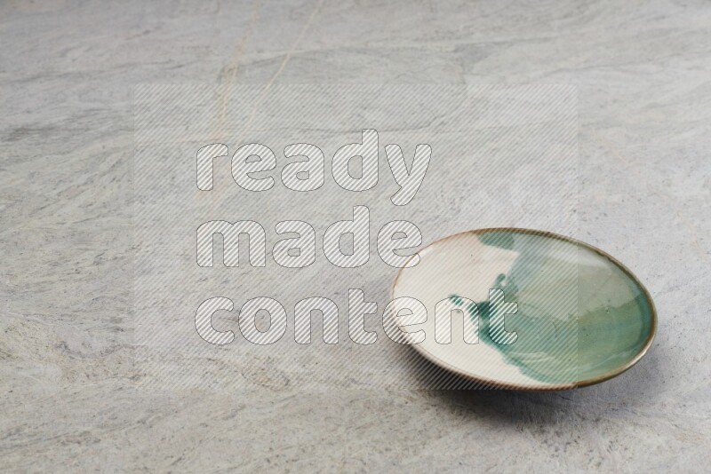 A multicolored pottery plate on grey marble background