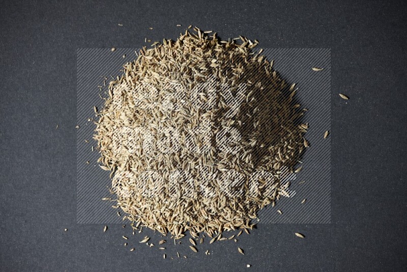 Cumin seeds on black flooring