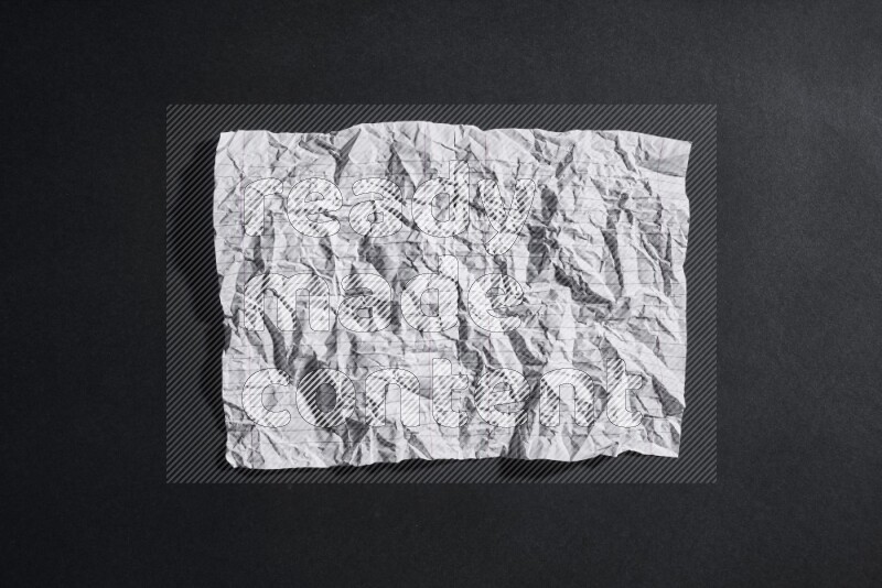 Crumpled notebook sheet on black background