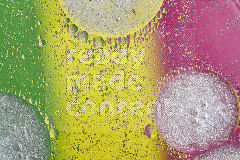 Close-ups of abstract oil bubbles on water surface in shades of yellow, green and pink