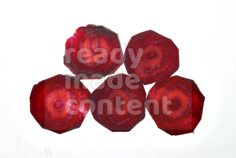 Beet slices on illuminated white background