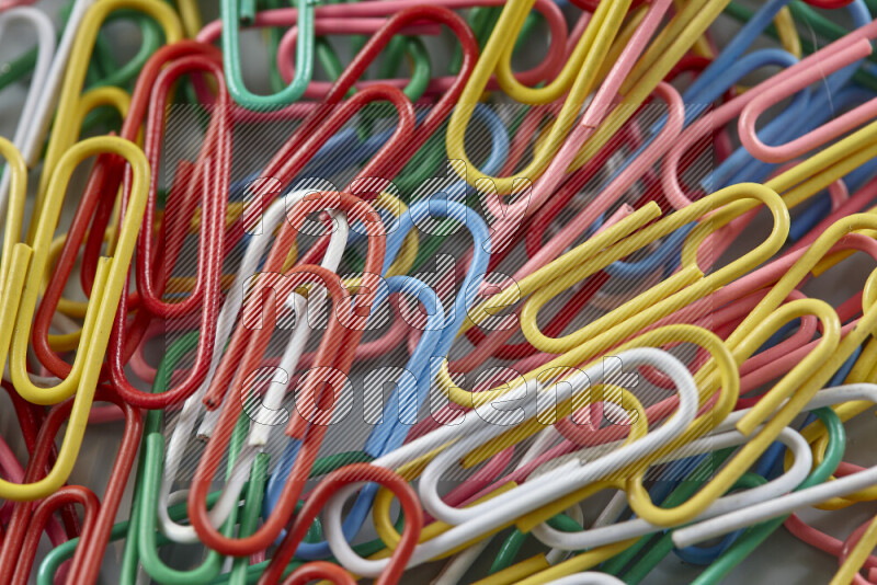 Multicolored paper clips isolated on a grey background