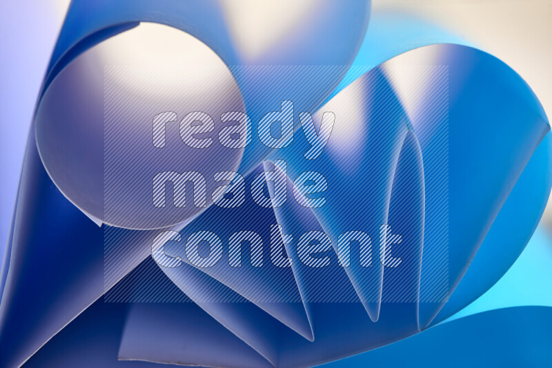 An artistic display of paper folds creating a harmonious blend of geometric shapes, highlighted by soft lighting in blue tones