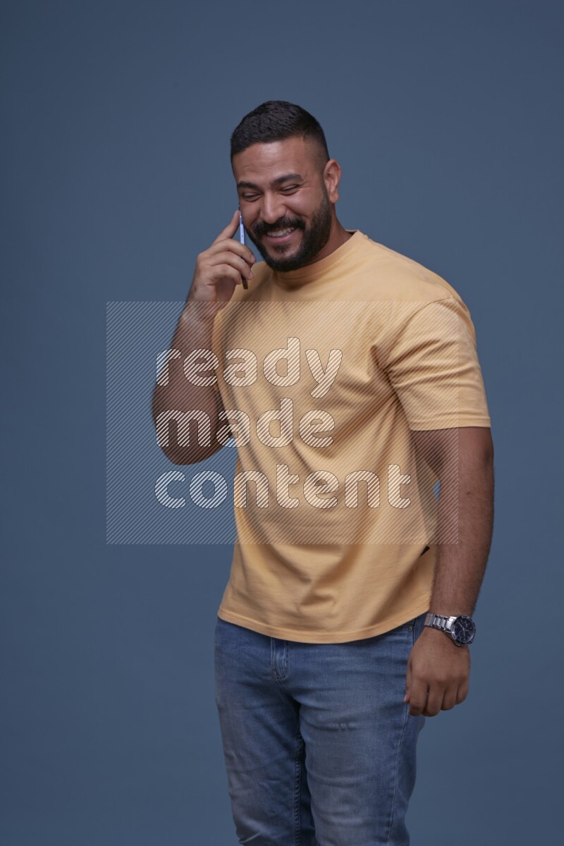 A man Calling on Blue Background wearing Orange T-shirt