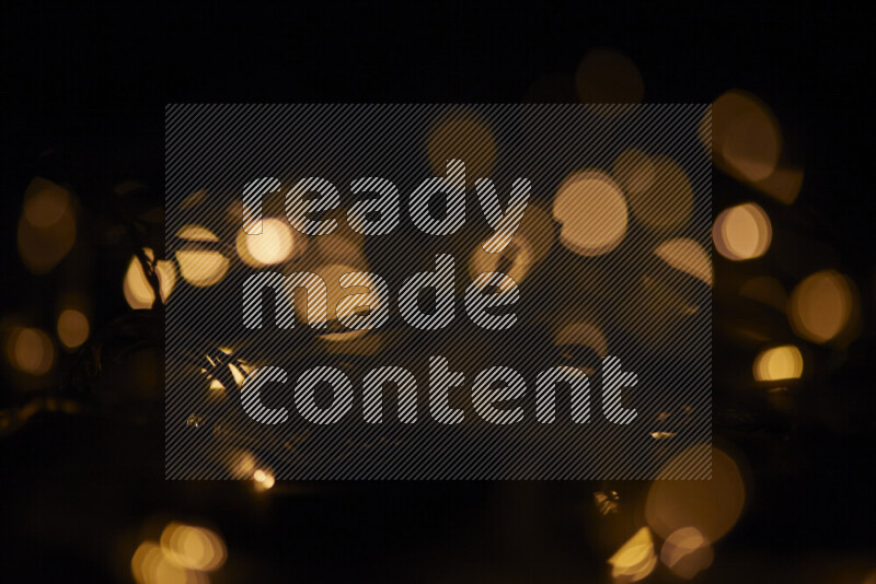 Light bulbs glowing against backdrop of golden bokeh