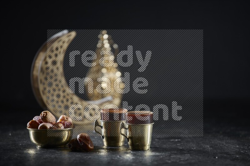 تمر مع مشروبات ساخنة وفوانيس ذهبية علي خلفية سوداء خشبية