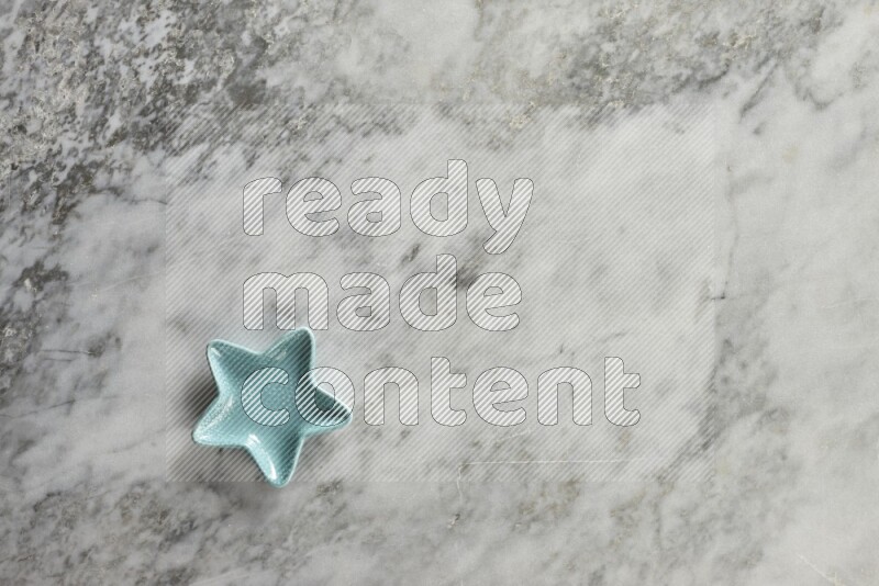 A colored pottery star plate on grey marble background