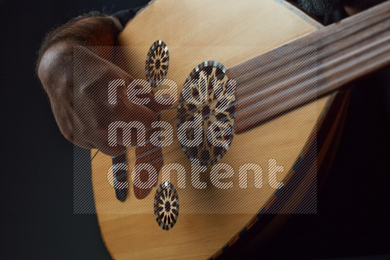 a hand intracting with a wooden brown Oud