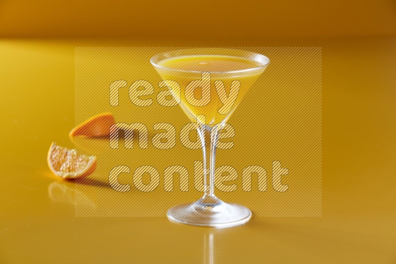 glass of orange juice on yellow background
