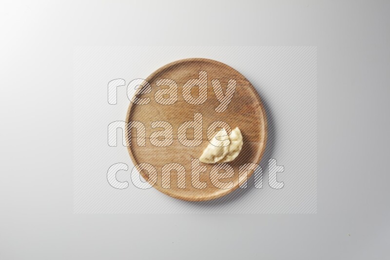 Two Sambosas on a wooden round plate on a white background
