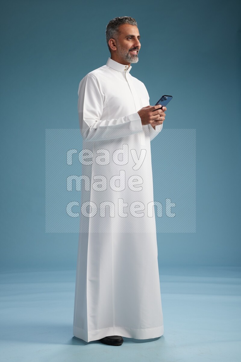 Saudi man waring thob texting on blue background