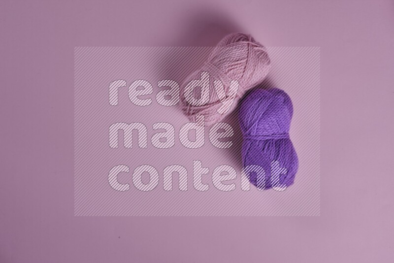 A purple and pink collection of sewing and tailoring tools arranged on a pink background