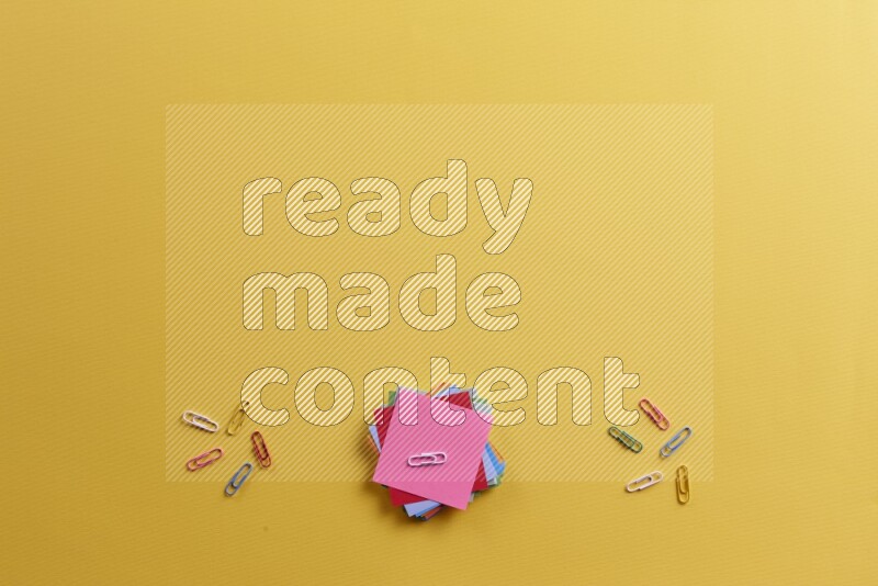 ورق ملاحظات متعدد الألوان مع مستلزمات مدرسية على خلفية صفراء