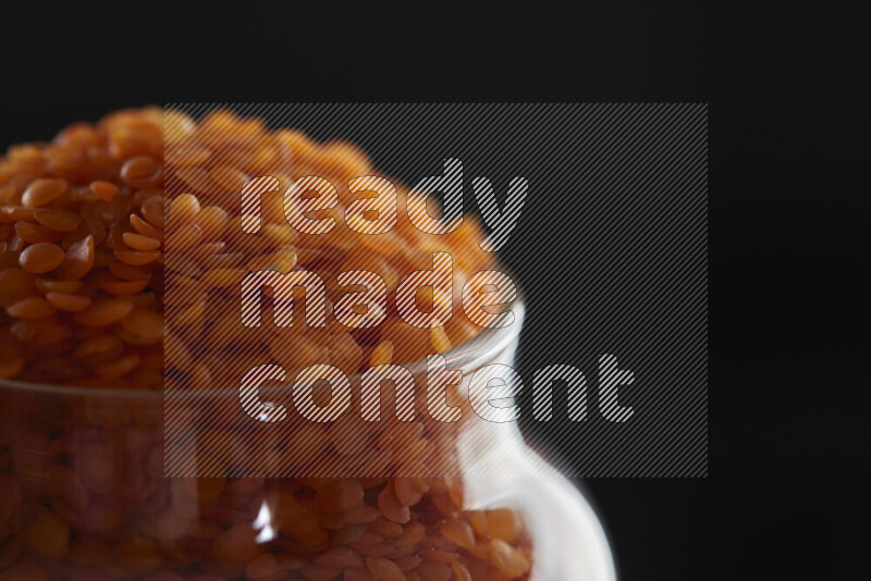 Lentils in a glass jar on black background