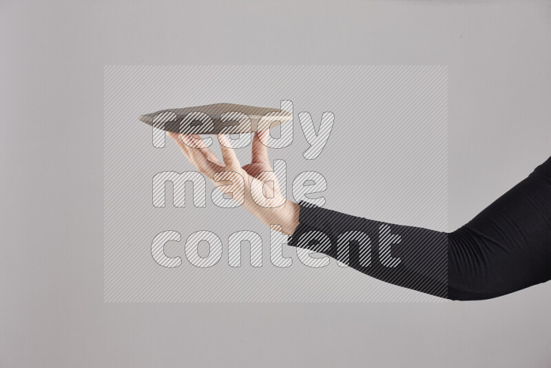 A woman in black abaya holding different pottery essentials in different positions