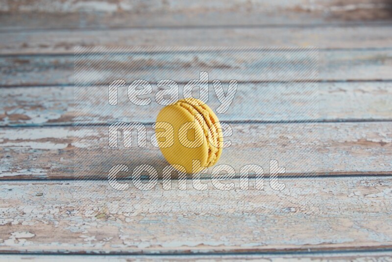 45º Shot of Yellow Lemon macaron on light blue wooden background