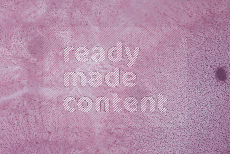 The image captures a dramatic splatter of purple paint over a white backdrop