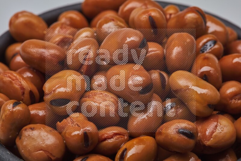 Close up shot of cooked fava beans (foul) on white background