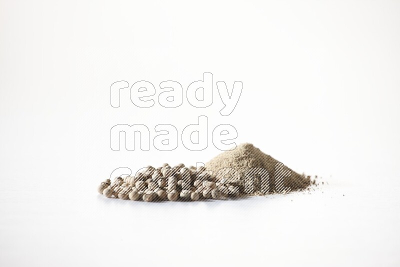 White pepper powder and pepper beads on white flooring