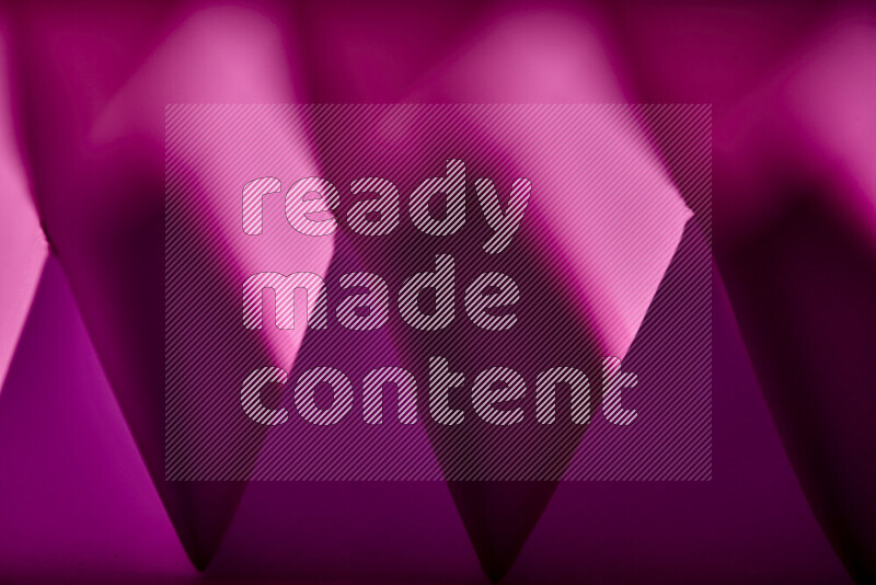 A close-up abstract image showing sharp geometric paper folds in purple gradients