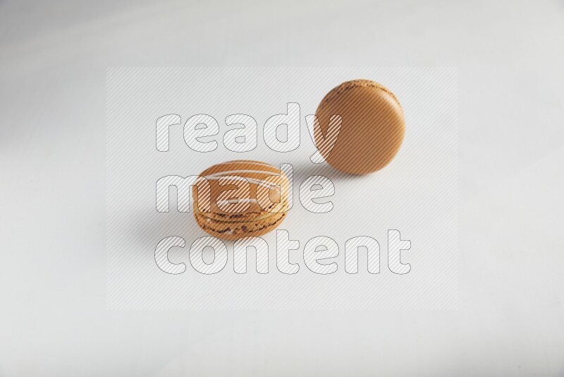 45º Shot of of two assorted Brown Irish Cream, and Brown Maple Taffy macarons  on white background