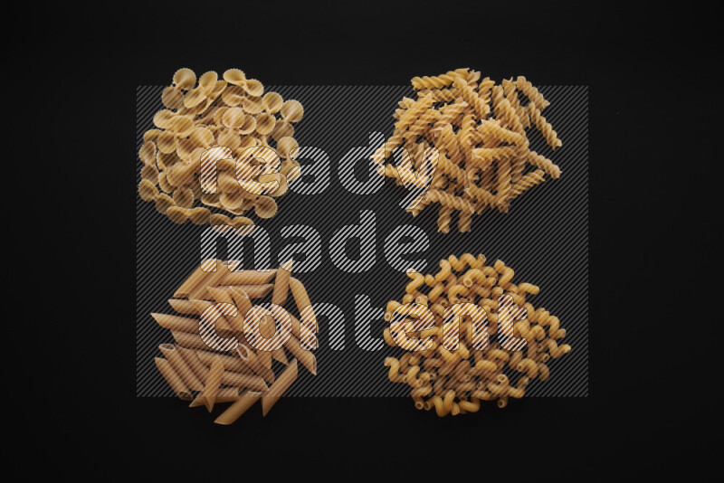 Different pasta types in bunches on black background