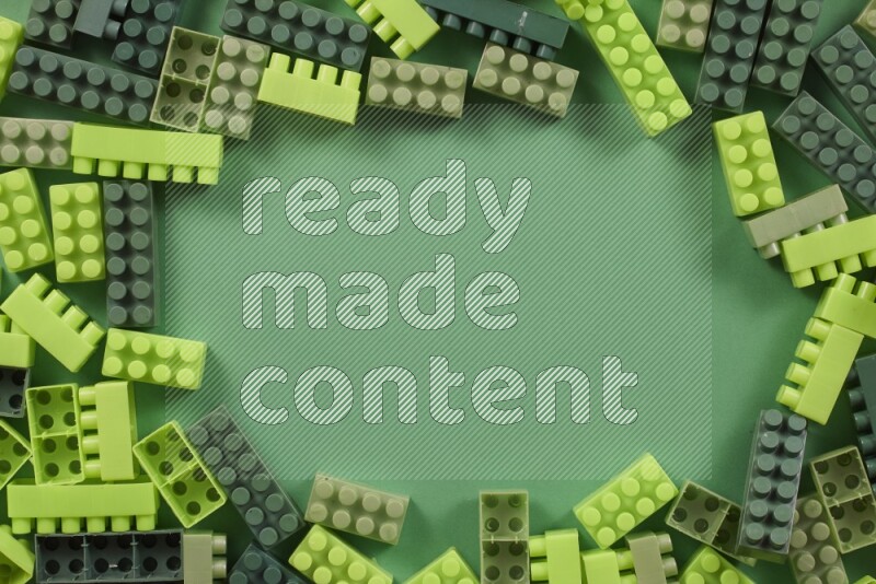 Green plastic building blocks on green background (kids toys)