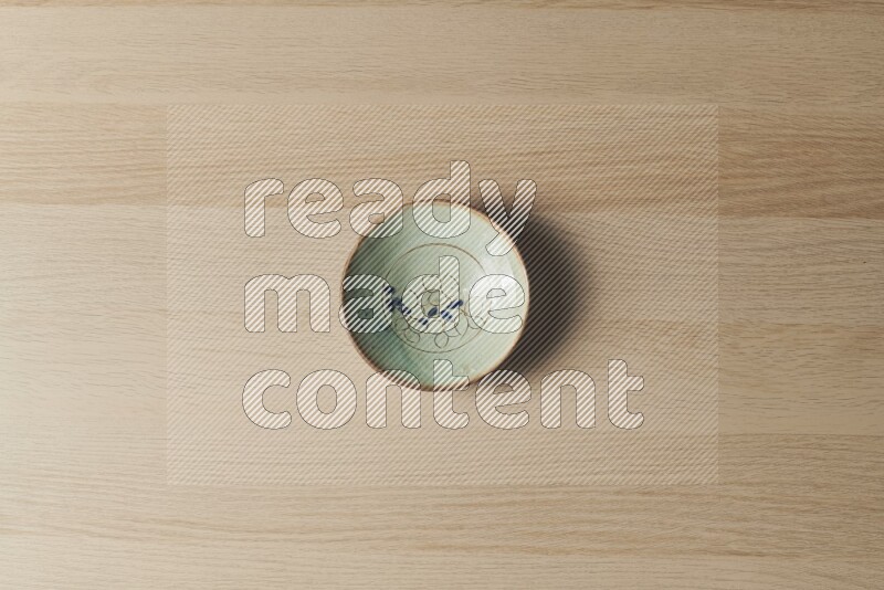 A decorative pottery plate on light wooden background