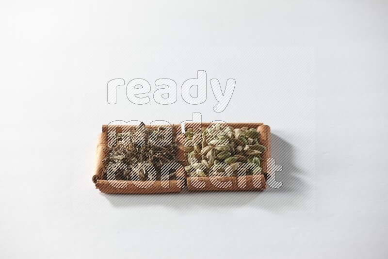 2 squares of cinnamon sticks full of cardamom and dried basil on white flooring