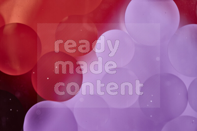 Close-ups of abstract oil bubbles on water surface in shades of red and pink