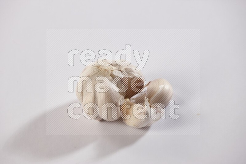 A whole garlic bulb placed on a white flooring