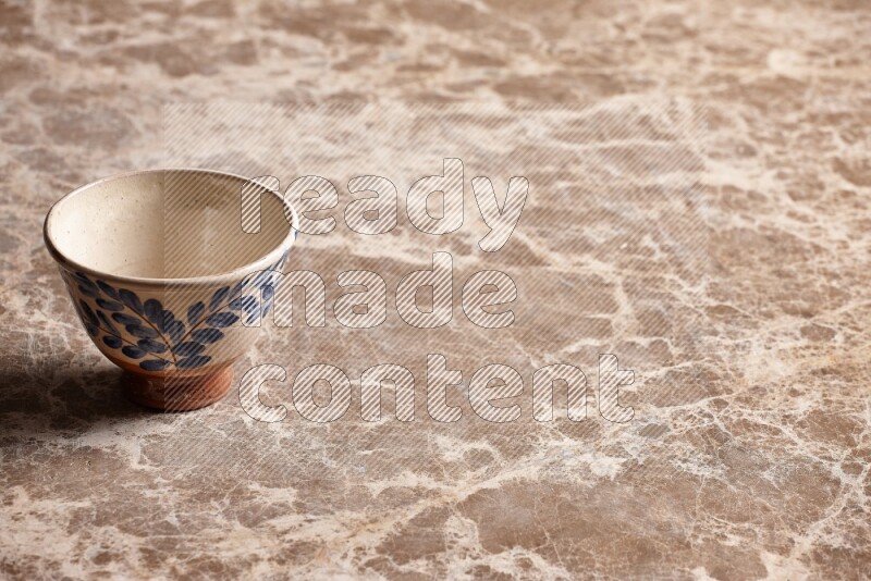 A decorative pottery bowl on beige marble background