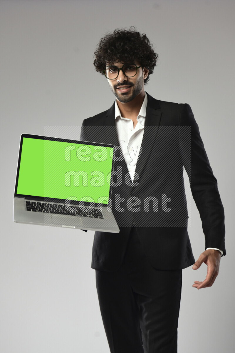 A man wearing formal standing and showing a laptop screen on white background