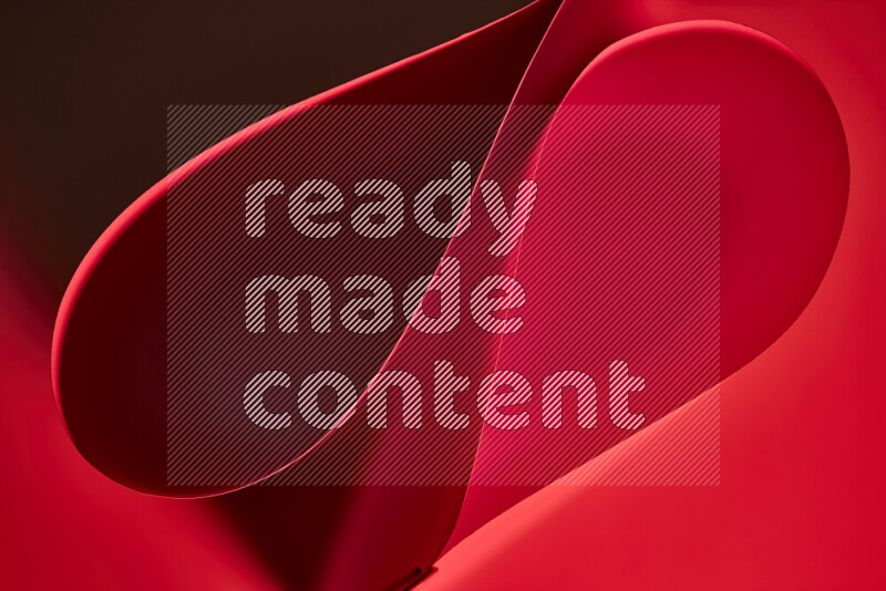 An abstract art of paper folded into smooth curves in red gradients