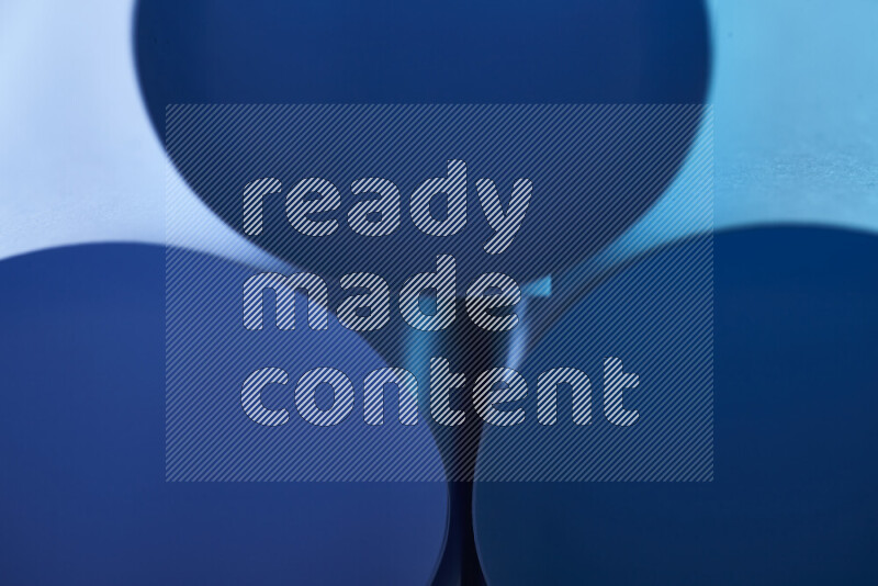 الصورة تعرض فن ورقي تجريدي بأشكال دائرية بدرجات متنوعة من اللون الأزرق