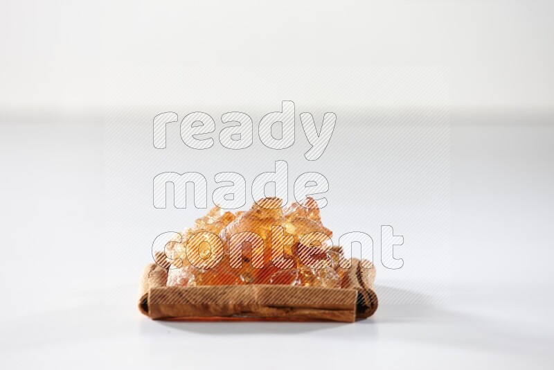 A single square of cinnamon sticks full of Arabic gum on white flooring