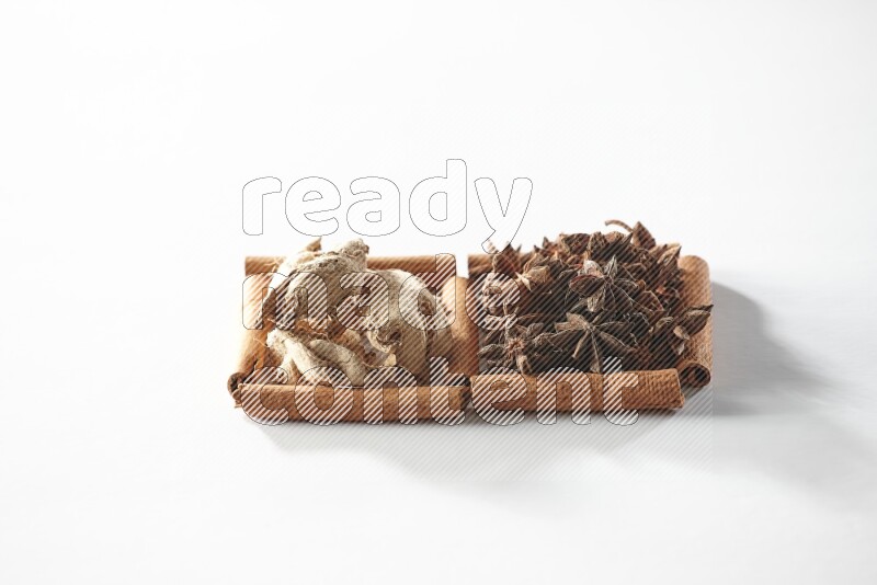 2 squares of cinnamon sticks full of star anise and dried ginger on white flooring