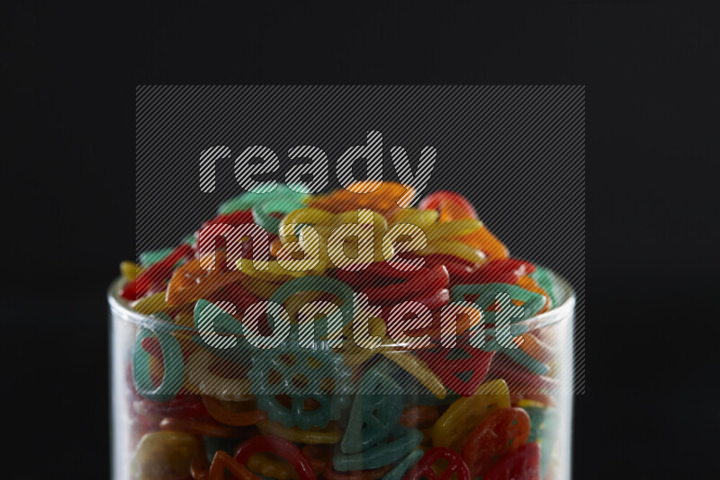 Snacks in a glass jar on black background