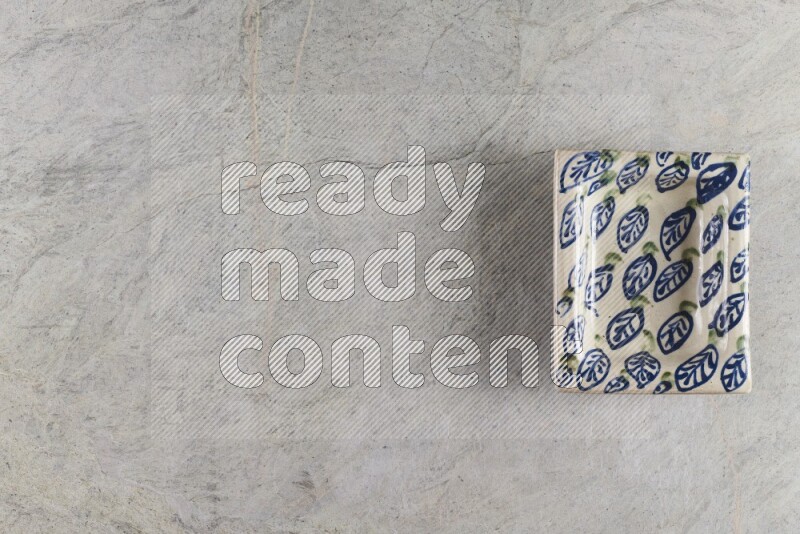 A decorative pottery plate on grey marble background