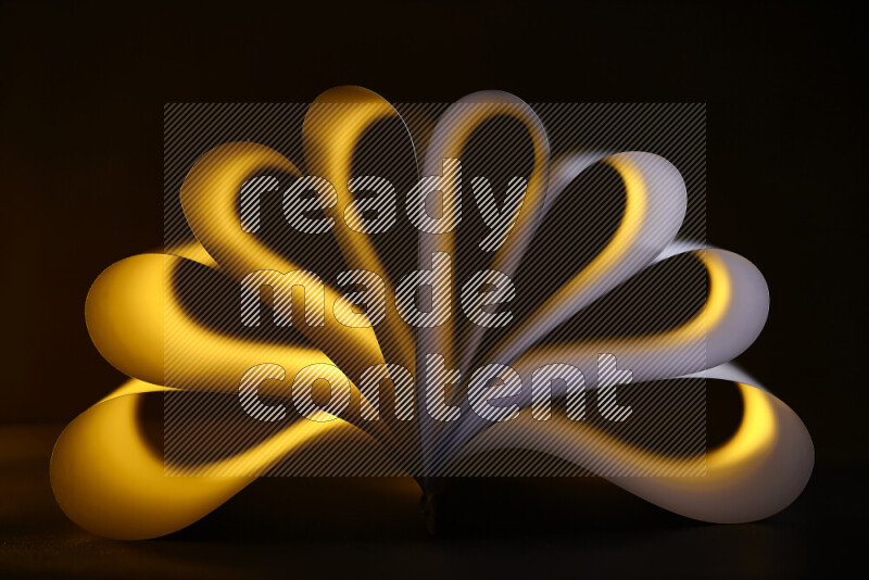An abstract art piece displaying smooth curves in yellow and white gradients created by colored light