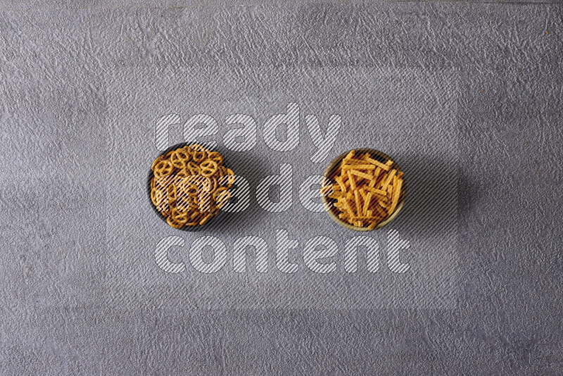 وجبات خفيفة متنوعة في أوعية فخارية على خلفية رمادية