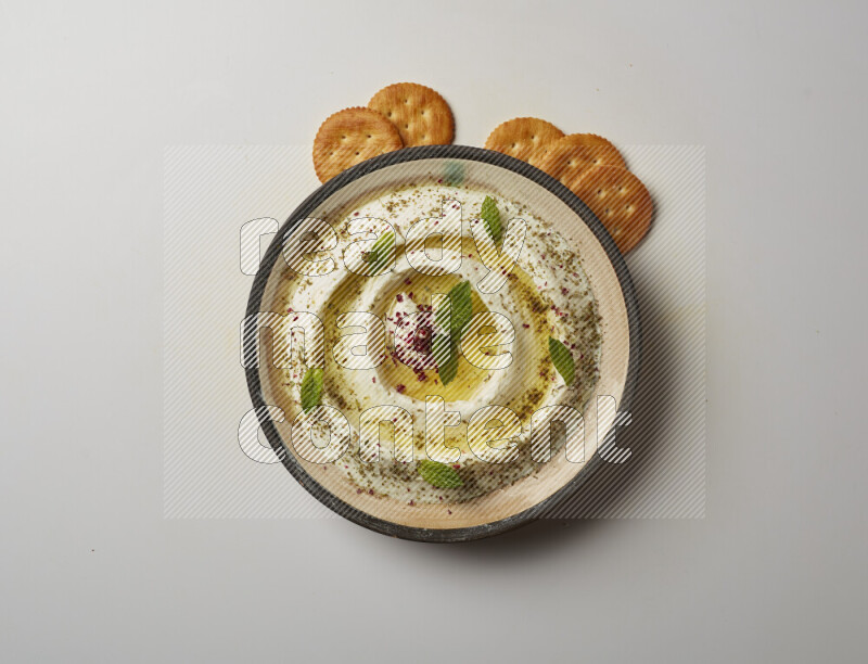 Lebnah garnished with zaater, mint & sumak in a pottery plate on a white background